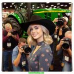 Oklahoma Dairy Show local woman and farmer, 20 something, blonde hair, dairy farmer chic fashion, arrives at the John Deere tractor and Holstein exhibit (3)