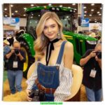 Oklahoma Dairy Show local woman and farmer, 20 something, blonde hair, dairy farmer chic fashion, arrives at the John Deere tractor and Holstein exhibit (5)